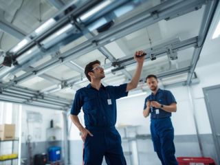 Garage Door Technicians Maintenance Conroe TX Garage door technicians performing maintenance on residential garage doors in Conroe, TX
