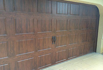 Professional installation of sectional faux wood garage door by technicians