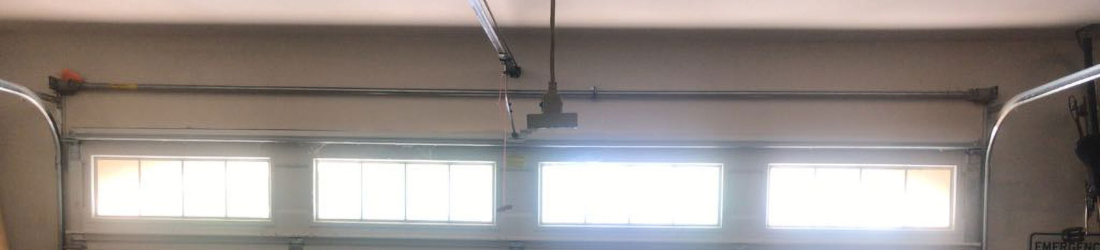 Frayed garage door cables and damaged steel tracks inside Conroe, Texas garage