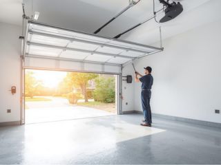Garage Door Tune-Up Conroe TX Technician inspecting and tuning up a residential garage door in Conroe, TX